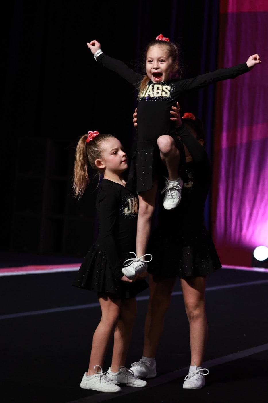 Novice Cheer athletes celebrating on stage